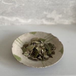 a saucer containing dried cracked souri olive leaves