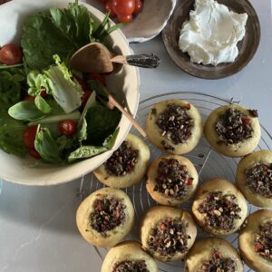 a salad with open meat pies sfiha