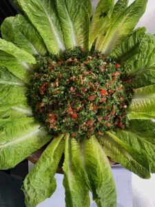 tabbouleh in a bowl with salad leaves