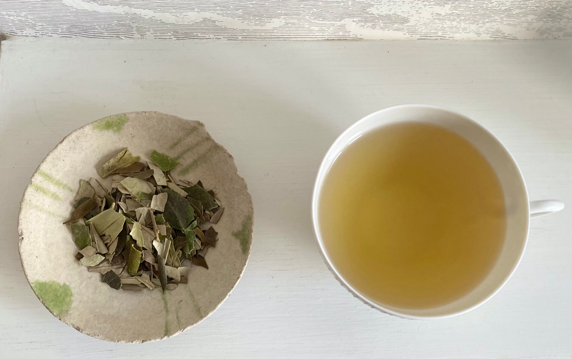 a saucer of dried cracked olive leaves from Beino north Lebanon and a cup of olive leaf infusion