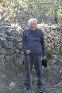 photo of Fares Fares aged 91 standing by a wall holding a stick