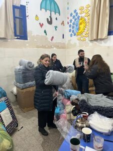Imane Nasraddine Aref with donations in Aleppo