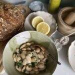 butter beans in a bowl with garlic, lemon, EVOO and some bread