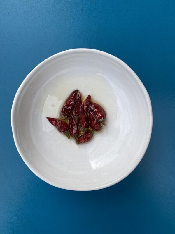 dried red chillis from the chilli infused oil on a saucer